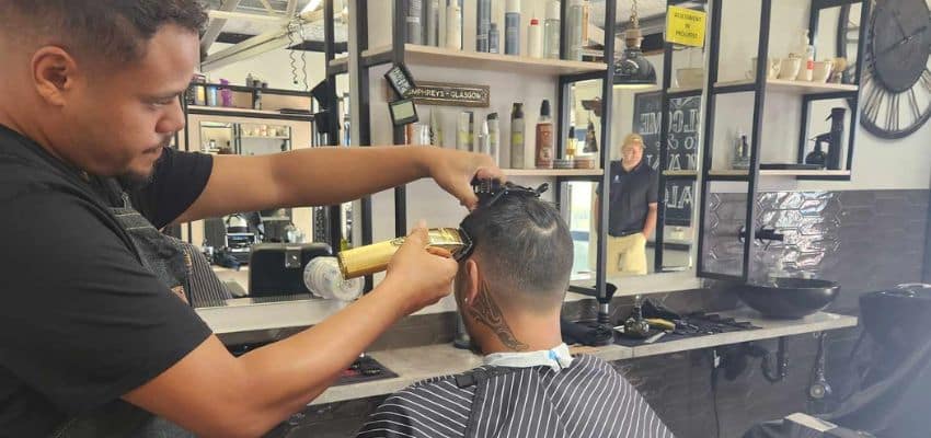 A man sitting in a barber salon getting a haircut