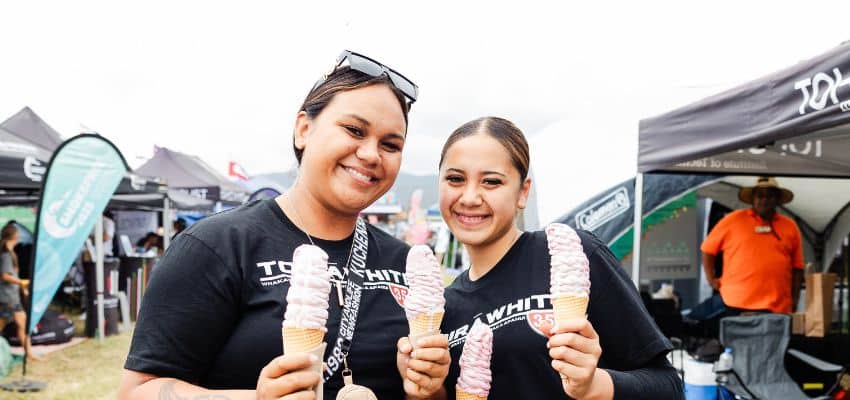 Two female youth smile for photo while holding icecream