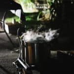 Steam rises from a pot sitting on a gas burner