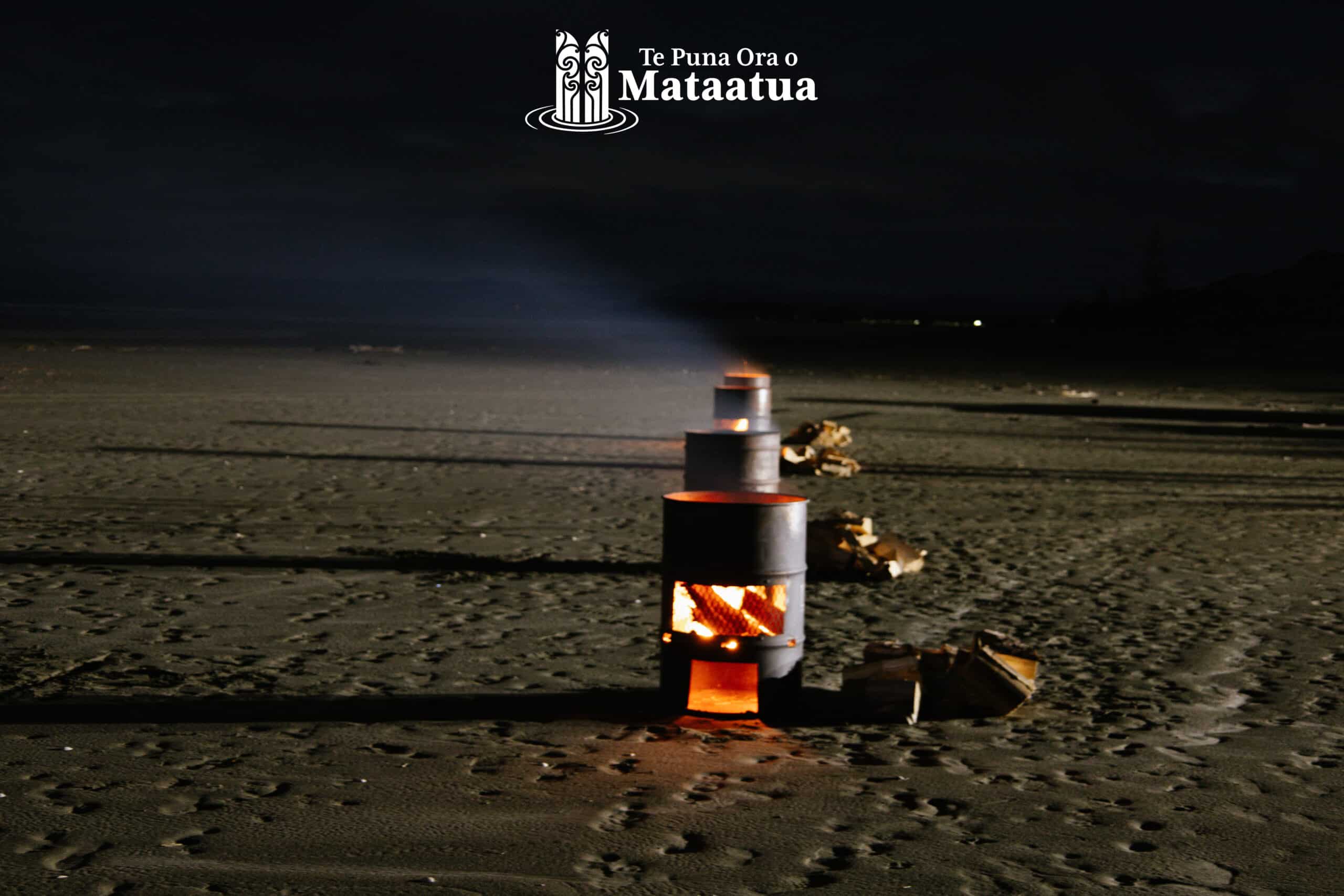 A line of bonfires on a beach