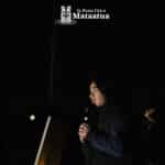 A group of children watch on as a small girl dressed in black gives a karakia/prayer