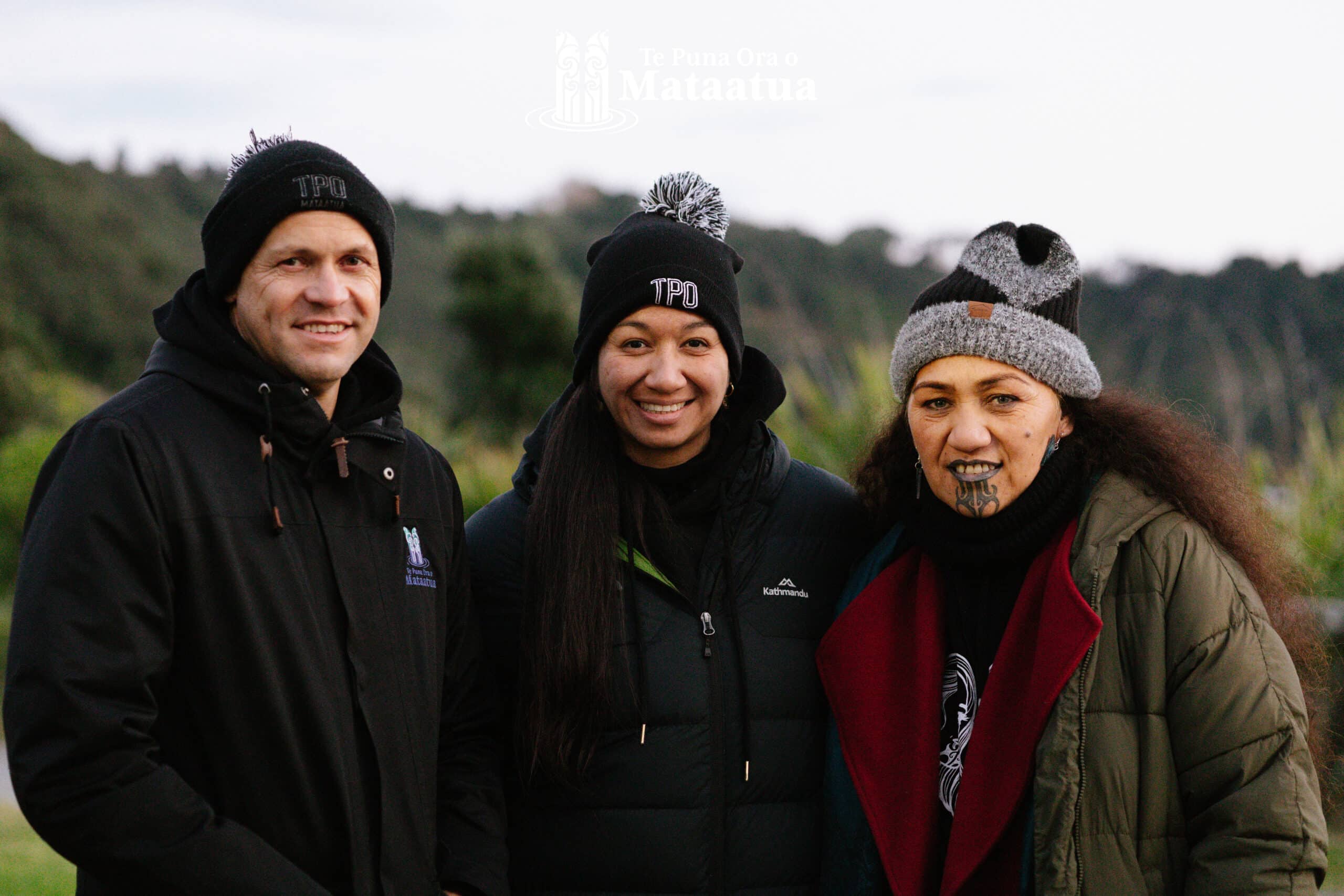 A group of people smiling against a bush ridgeline